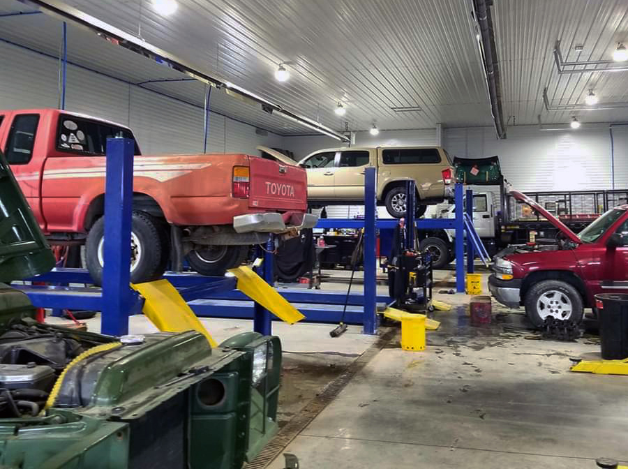 auto repair shop with cars on the lift